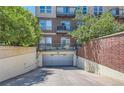 A secure parking garage entrance nestled beneath the building with brick and concrete elements at 10184 Park Meadows Dr # 1317, Lone Tree, CO 80124