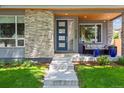 Modern home with a blue front door, stone accents and a cozy outdoor seating area at 4220 Quitman St, Denver, CO 80212