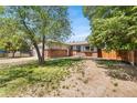 Attractive home boasting a brick facade, a spacious front yard, and mature trees at 12829 E Nevada Ave, Aurora, CO 80012
