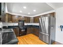 Functional kitchen featuring modern appliances, dark wooden cabinets, and solid surface countertops at 12829 E Nevada Ave, Aurora, CO 80012