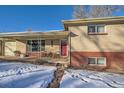 Covered porch with red door and stone pathway at 7625 W 23Rd Pl, Lakewood, CO 80214