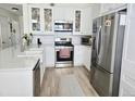 Bright kitchen featuring stainless steel appliances, white cabinetry, and a center island with a sink at 8500 E Jefferson Ave # G, Denver, CO 80237