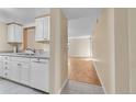 Clean kitchen with white cabinets and a view into the adjacent living room at 6410 S Dayton St # I1, Englewood, CO 80111