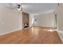 Spacious living room featuring hardwood floors, a stone fireplace, and a ceiling fan at 6410 S Dayton St # I1, Englewood, CO 80111