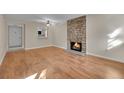 Bright living room with wood floors, a stone fireplace, and a pass-through to the kitchen at 6410 S Dayton St # I1, Englewood, CO 80111