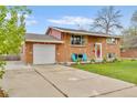 Beautiful brick home featuring an attached garage and a well-maintained front yard at 4544 W 65Th Ave, Arvada, CO 80003