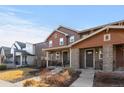 Attractive home with a welcoming front porch, stone accents, and well-maintained landscaping at 11420 E 26Th Ave, Aurora, CO 80010