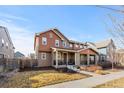 Beautiful home featuring a charming front porch with cozy seating and manicured landscaping at 11420 E 26Th Ave, Aurora, CO 80010