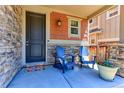 Charming front porch featuring a cozy seating area with Adirondack chairs and colorful flower pot at 13713 Raritan Ln, Broomfield, CO 80023