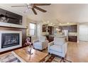 Cozy living room features a fireplace, ceiling fan, and open layout connecting to the modern kitchen at 13713 Raritan Ln, Broomfield, CO 80023