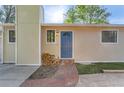 Charming home featuring a blue front door with a quaint brick walkway and woodpile at 6396 Twin Lakes Rd, Boulder, CO 80301