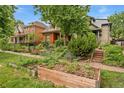 Charming home featuring a landscaped front yard, garden boxes, and inviting porch steps at 2253 N Williams St, Denver, CO 80205