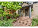 Inviting front porch with brick steps, columns, a secure door, and well-maintained landscaping at 2253 N Williams St, Denver, CO 80205