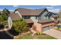 Two-story home with a lush green lawn, a stone path and three car garage at 16652 W Archer Ave, Golden, CO 80401