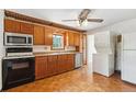 Functional kitchen with wooden cabinets, black appliances, and unique parquet flooring at 1175 Xanthia, Denver, CO 80220