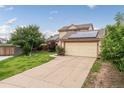 Well-maintained home with a spacious driveway, two-car garage, solar panels, and lush front lawn at 9563 Milwaukee Ct, Thornton, CO 80229