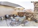 A cozy outdoor patio with a stone wall features comfortable seating and an umbrella-covered table at 16791 W 48Th Ln, Golden, CO 80403