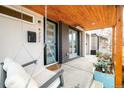 Covered porch with a swing and modern light fixtures at 4222 Stuart St, Denver, CO 80212