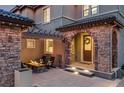 Inviting front porch with a stone fireplace, a pergola, and a cozy seating area at 10757 Timberdash Ave, Highlands Ranch, CO 80126