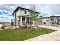 Attractive two-story home featuring a lush green lawn, young tree, and inviting curb appeal at 24790 E 39Th Ave, Aurora, CO 80019