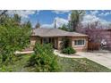Beautifully maintained brick home with lush greenery and flowering trees, offering a serene outdoor space at 3031 W 20Th Ave, Denver, CO 80211