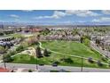 Scenic aerial view showcasing a neighborhood park, tree-lined streets, and mountain views in the distance at 3031 W 20Th Ave, Denver, CO 80211
