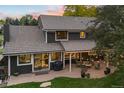 Back of the home with string lights, patio furniture, and beautiful landscaping at 6128 S Coventry E Ln, Littleton, CO 80123