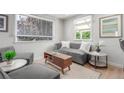 Bright living room featuring a modern sofa, stylish coffee table, and natural light from large windows with blinds at 2845 Eaton St, Wheat Ridge, CO 80214