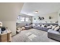 Spacious basement living area featuring plush carpeting and a comfortable sectional sofa at 12425 Bellaire Dr, Thornton, CO 80241
