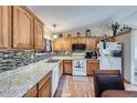 Charming kitchen features wooden cabinets, granite countertops, and mosaic tile backsplash at 12425 Bellaire Dr, Thornton, CO 80241