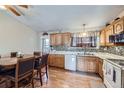 Well-lit eat-in kitchen with granite countertops, modern appliances, and wooden dining set at 12425 Bellaire Dr, Thornton, CO 80241