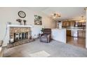 Inviting living room features a fireplace, cozy armchair and natural light at 12425 Bellaire Dr, Thornton, CO 80241