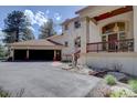 Detailed view of the stucco exterior, tile roof, and attached garage at 2828 Keystone Dr, Evergreen, CO 80439