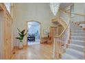 Grand foyer with a chandelier, staircase, and a glimpse into the dining room at 2828 Keystone Dr, Evergreen, CO 80439
