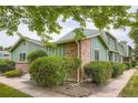 Angle view of charming green-sided home with brick accents and lush landscaping at 400 S Balsam St, Lakewood, CO 80226