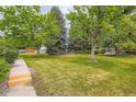 Expansive front lawn with mature trees offers shade and curb appeal to this property at 400 S Balsam St, Lakewood, CO 80226