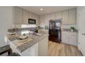 Well-lit kitchen boasts granite countertops, sleek black appliances, and ample cabinet space at 13111 E 103Rd Pl, Commerce City, CO 80022