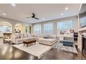 Open-concept living room with hardwood floors, recessed lighting, large sectional couch, and modern ceiling fan at 6401 S Millbrook Way, Aurora, CO 80016