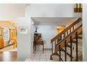 Bright foyer with tile floors, wooden staircase, and charming decor at 3709 S Fairplay Way, Aurora, CO 80014