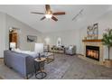 Spacious living room with a fireplace, ceiling fan, and ample natural light at 7040 Routt St, Arvada, CO 80004