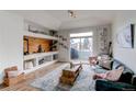 Bright living room with vaulted ceilings, custom built-ins, and sliding glass door to the outdoor patio at 8500 E Jefferson Ave # 7B, Denver, CO 80237