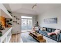 Sunlit living room features modern decor, plush seating, and a sliding glass door to the outside patio at 8500 E Jefferson Ave # 7B, Denver, CO 80237