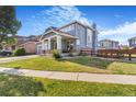 Attractive two-story home with a large front lawn, covered porch and beautiful exterior paint at 10301 E 112Th Way, Commerce City, CO 80640
