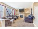 Cozy living room featuring a fireplace, neutral walls, and comfortable seating for relaxation at 10301 E 112Th Way, Commerce City, CO 80640
