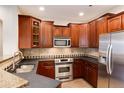 Well-equipped kitchen features stainless steel appliances, wood cabinets, and dark countertops at 10100 Bluffmont Ln, Lone Tree, CO 80124