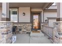 Welcoming front entrance with a glass-paneled door, a 'Welcome' mat, and stone accents that add character at 8104 El Jebel Loop, Castle Rock, CO 80108