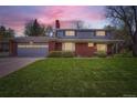 Lovely two-story home with brick and siding exterior, featuring a lush green lawn and a two-car garage at 11754 W 28Th Ave, Lakewood, CO 80215