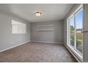 Bright living room with neutral walls and carpeting and a large window offering natural light at 1043 Lilac Ct, Broomfield, CO 80020