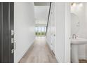Bright entryway featuring wood floors, white walls, a powder room, and an open view of the backyard at 8245 Butte Creek St, Littleton, CO 80125