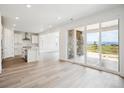 Open living area with wood floors, a modern kitchen, and sliding glass doors to a fenced patio at 8245 Butte Creek St, Littleton, CO 80125
